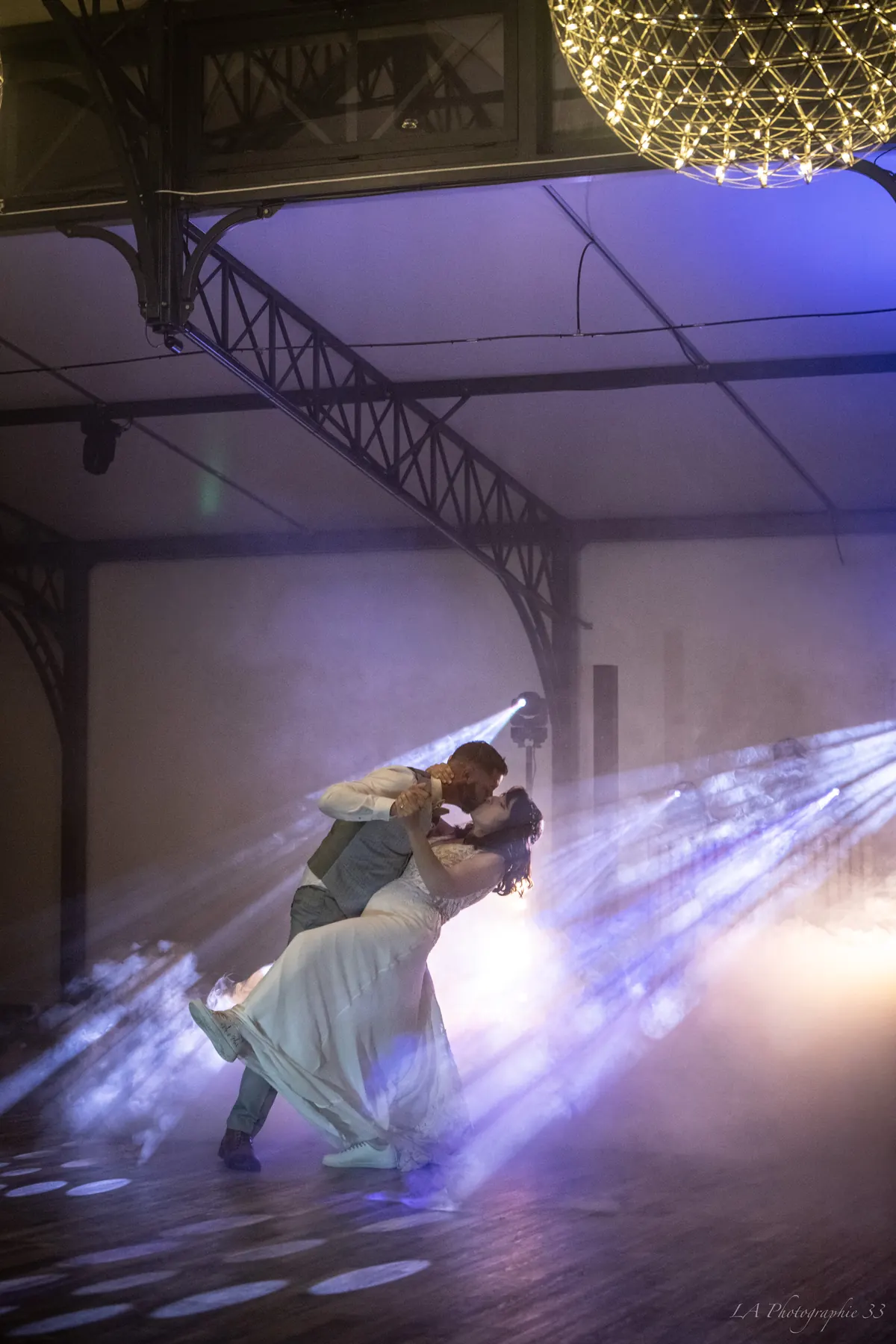 Les mariés dansent leur première danse, dans un halo de lumière et de fumée